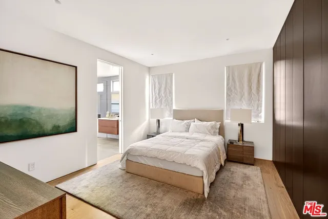 a bedroom with a bed lamp and a potted plant