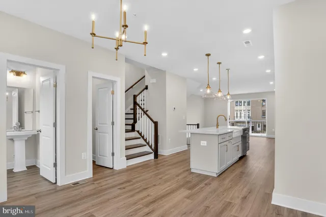 a living room with a sink chandelier and wooden floor