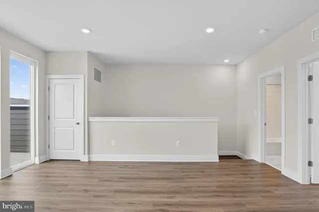 a view of empty room with wooden floor