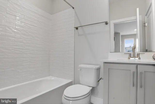 a bathroom with a shower sink vanity and toilet