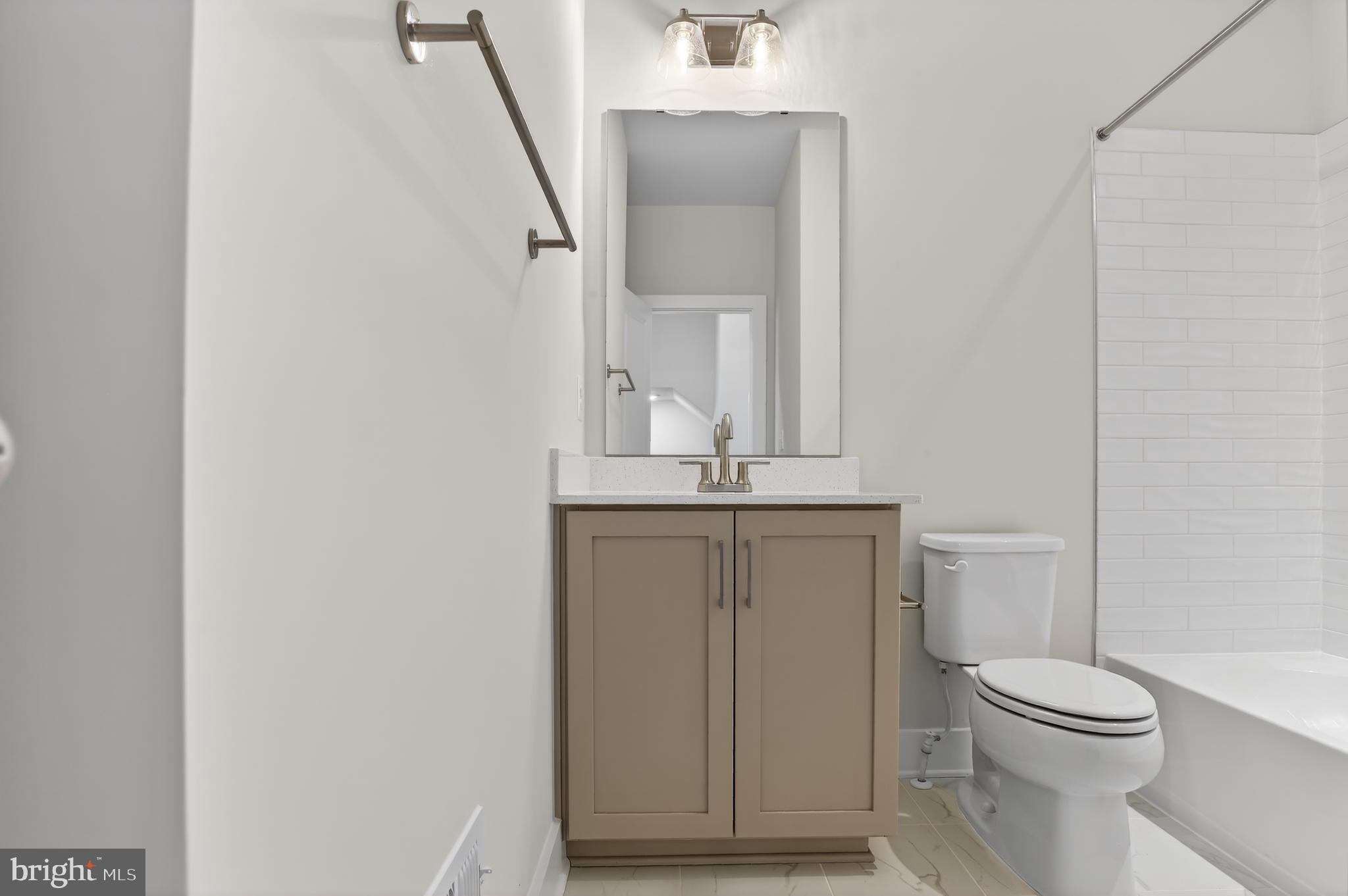 2710 Light Street Baltimore, MD 21230 - Photo 22 of 24 a bathroom with a toilet a sink and mirror