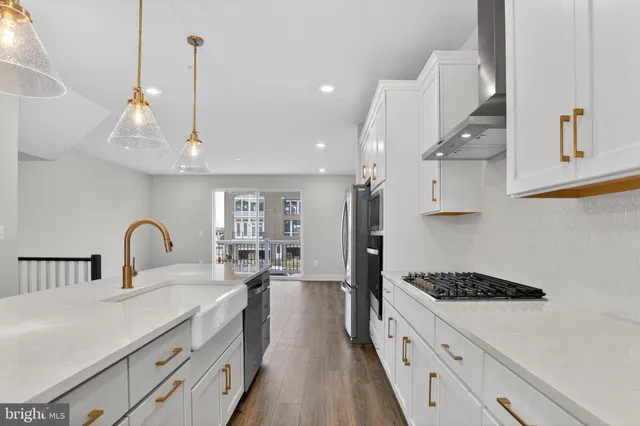 a large kitchen with white cabinets and stainless steel appliances