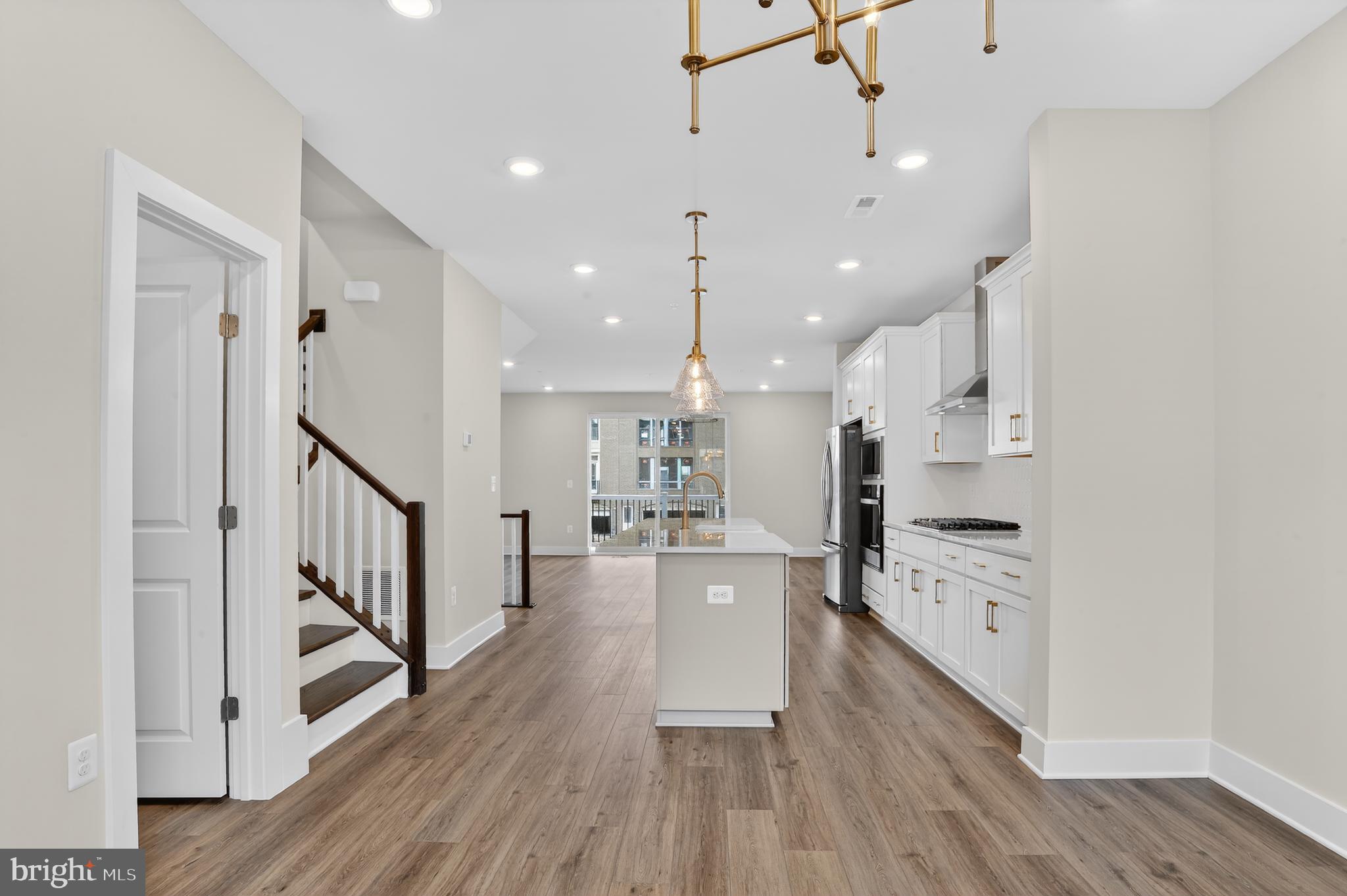 2710 Light Street Baltimore, MD 21230 - Photo 7 of 25 a large kitchen with white cabinets and stainless steel appliances