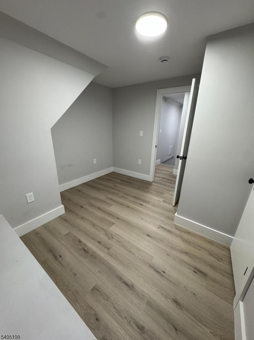 859 South 16th Street, Unit 2 Newark, NJ 07108 - Photo 14 of 14 an empty room with wooden floor and mirror