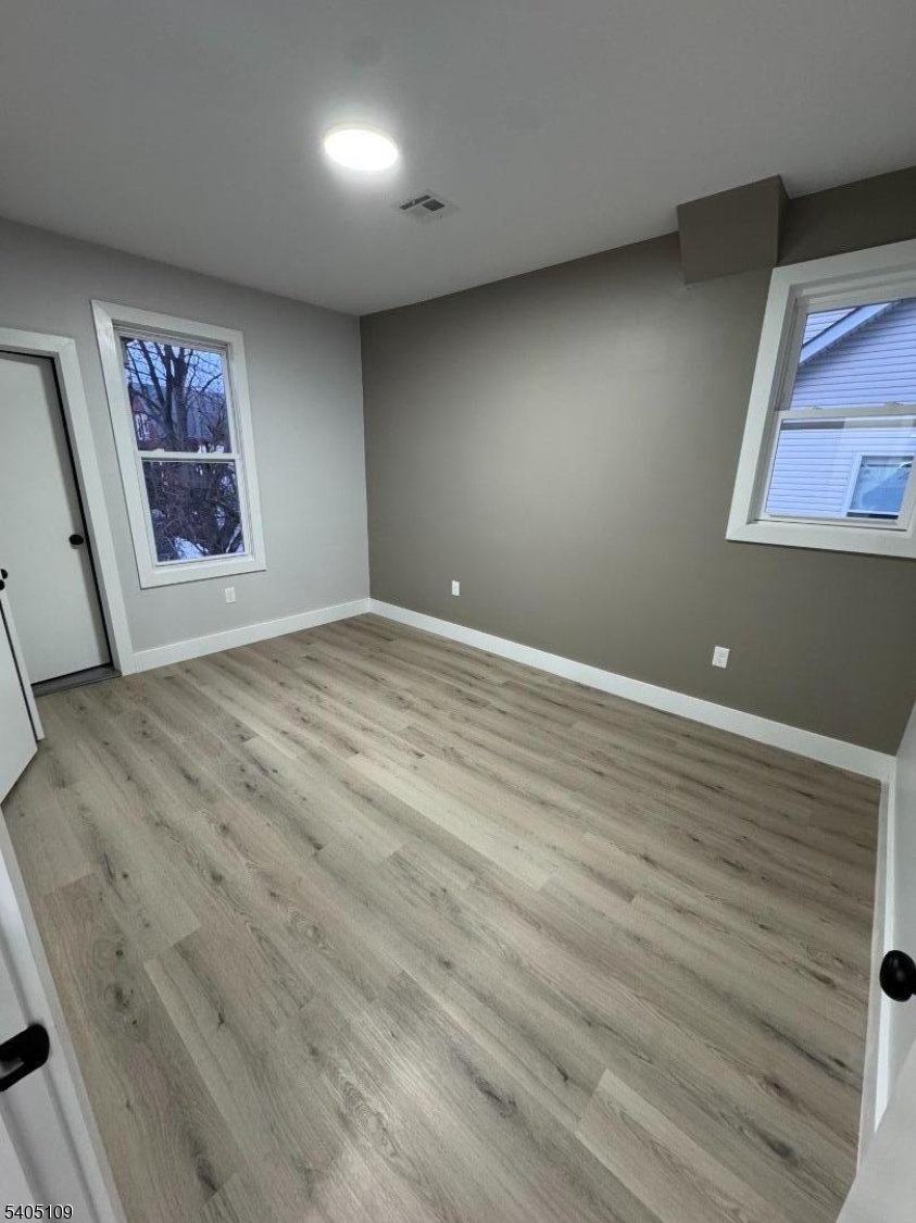 859 South 16th Street, Unit 2 Newark, NJ 07108 - Photo 3 of 14 an empty room with wooden floor and windows