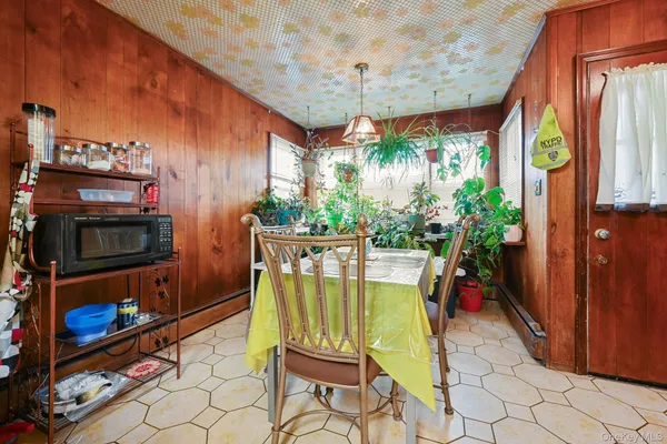 a kitchen with stainless steel appliances kitchen island granite countertop a table chairs and a refrigerator