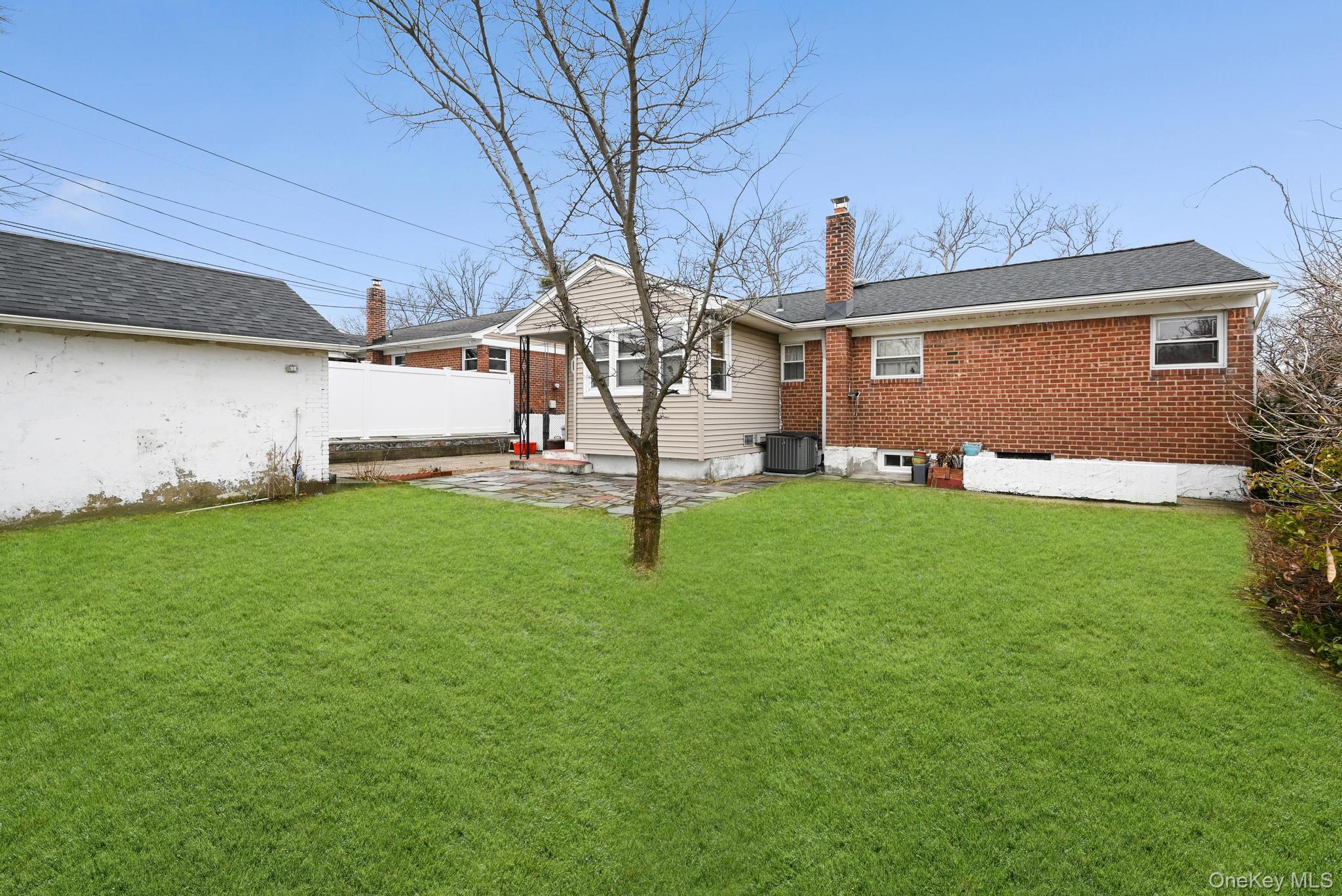 2225 Leighton Road Elmont, NY 11003 - Photo 23 of 26 a front view of a house with a yard and trees