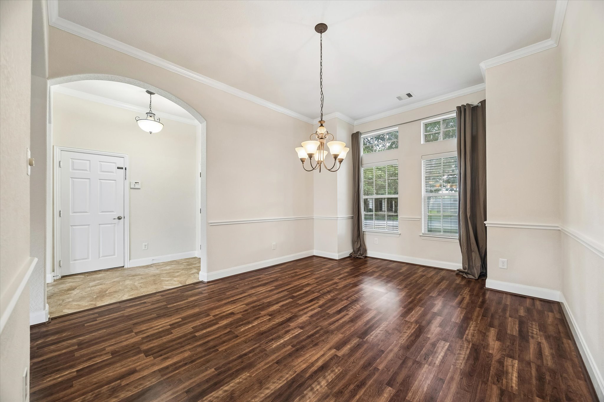 2214 Wembley Way Rosenberg, TX 77471 - Photo 9 of 35 Spacious interior featuring wood-finish flooring, an arched entryway, and crown molding