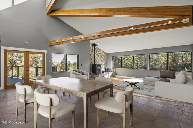a kitchen with stainless steel appliances granite countertop a table chairs sink and cabinets