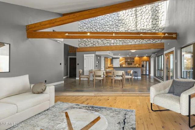a kitchen with stainless steel appliances a dining table chairs and a refrigerator