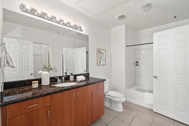 a bathroom with a double vanity sink toilet mirror and shower