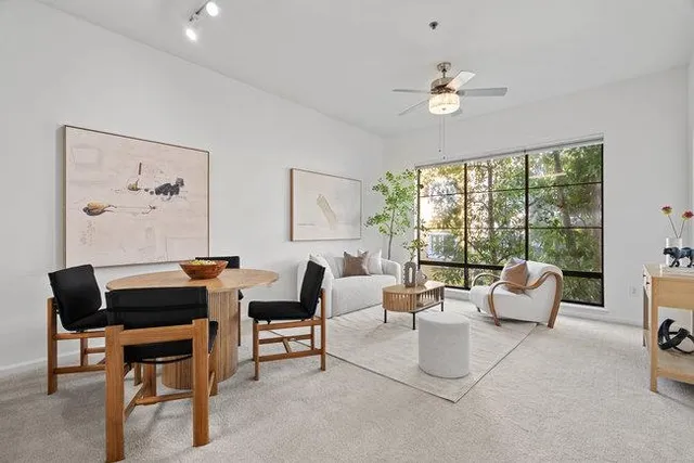 a living room with furniture and large windows