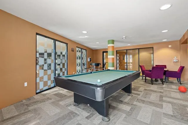 a room with pool table and glass windows