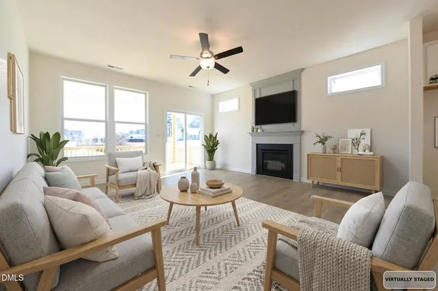 an empty room with wooden floor ceiling fan and windows