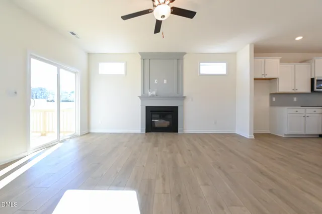 a view of a livingroom with a ceiling fan and kitchen floor