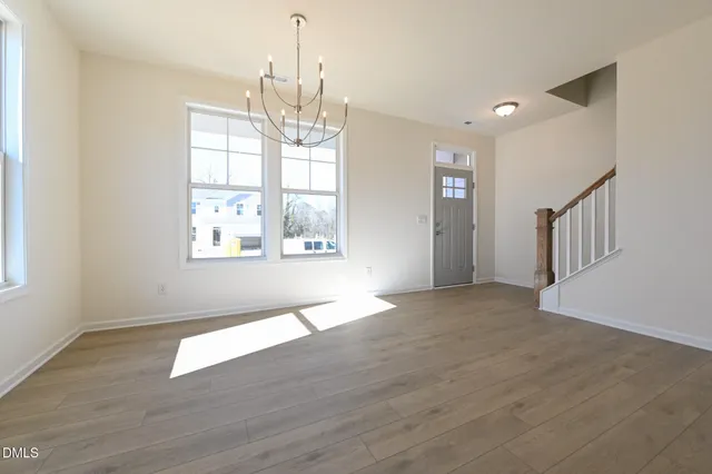 a large kitchen with a center island wooden floor stainless steel appliances and a window