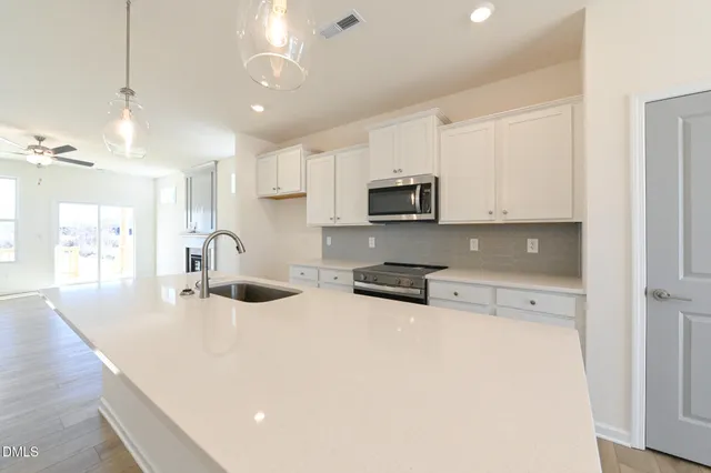 a large kitchen with stainless steel appliances kitchen island a large counter top and a sink