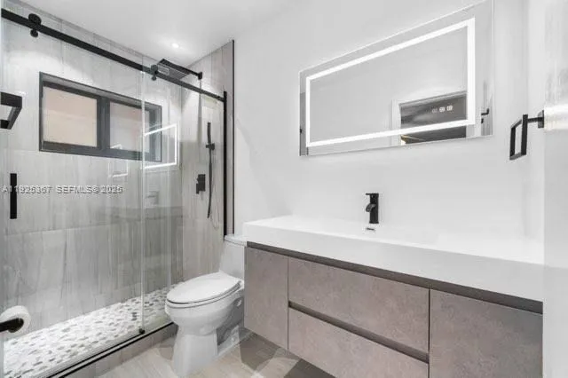 a bedroom with a bed and a flat tv screen on dresser