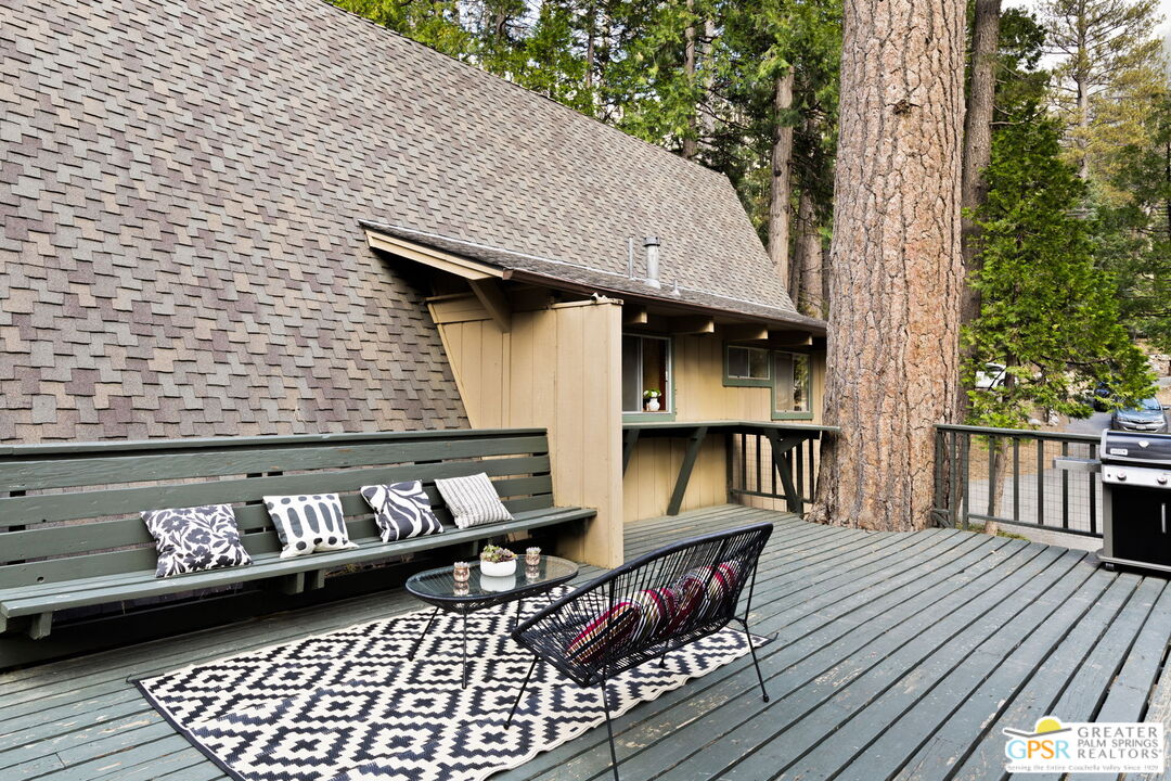 24601 Fern Valley Road Idyllwild, CA 92549 - Photo 39 of 50 a view of a patio with table and chairs with wooden floor and fence