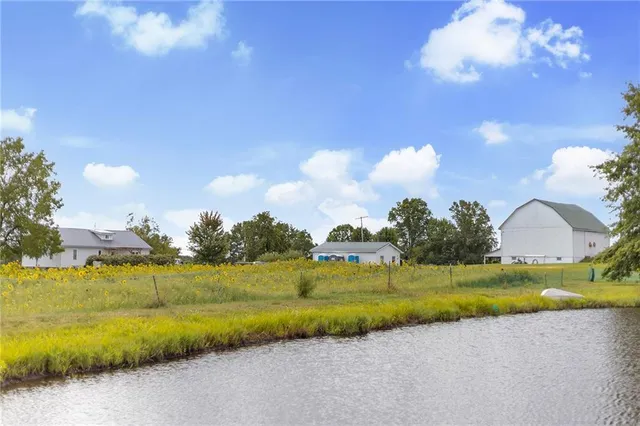 a front view of house with yard and trees in the background