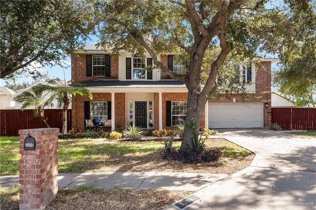 a front view of a house with garden and patio