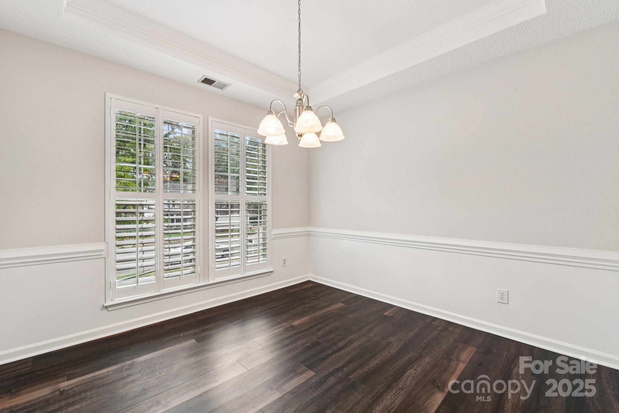 8700 Barrister Way Charlotte, NC 28216 - Photo 11 of 25 a view of a livingroom with wooden floor and a chandelier
