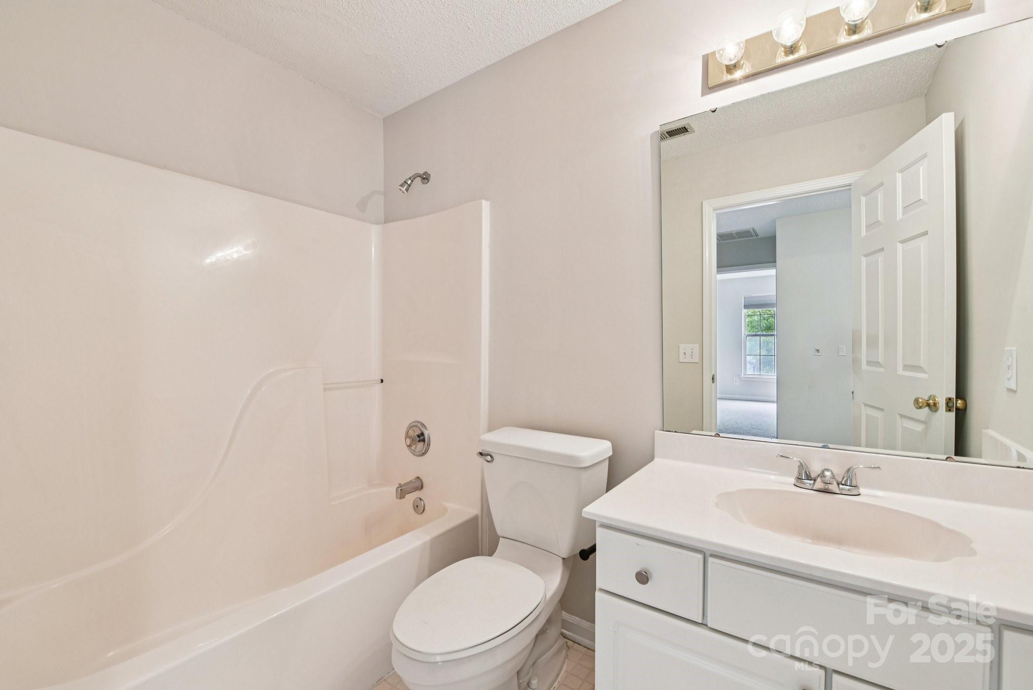 8700 Barrister Way Charlotte, NC 28216 - Photo 16 of 25 a bathroom with a toilet a sink a mirror a bathtub and shower
