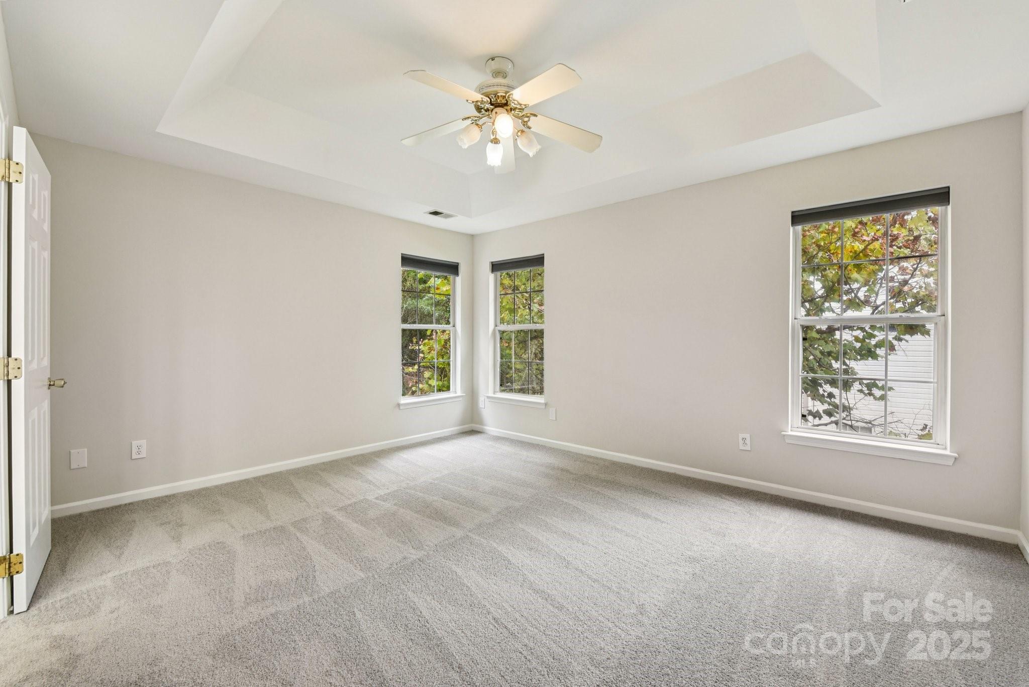8700 Barrister Way Charlotte, NC 28216 - Photo 18 of 25 an empty room with windows and chandelier fan
