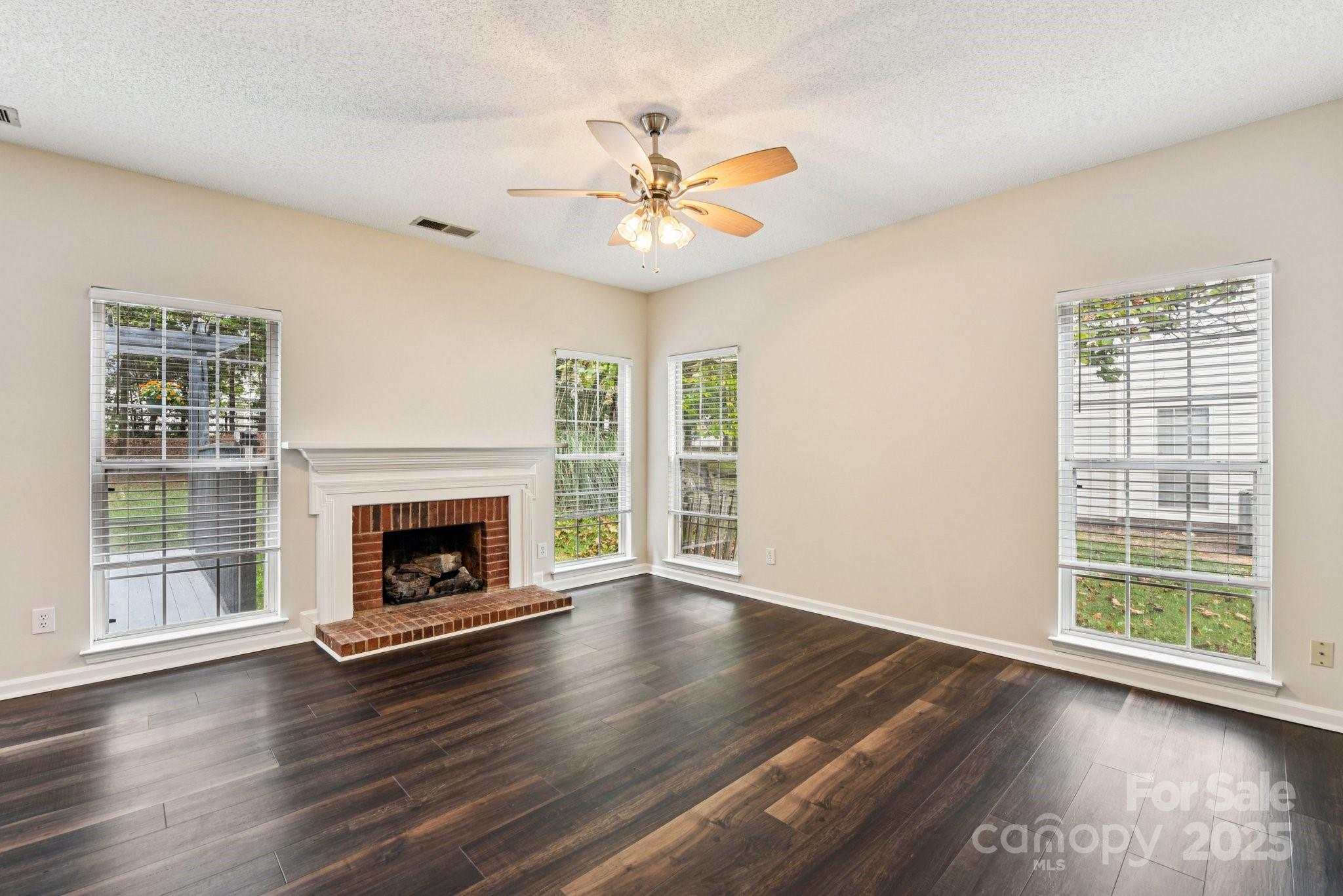 8700 Barrister Way Charlotte, NC 28216 - Photo 3 of 25 a view of an empty room with wooden floor fireplace and a window