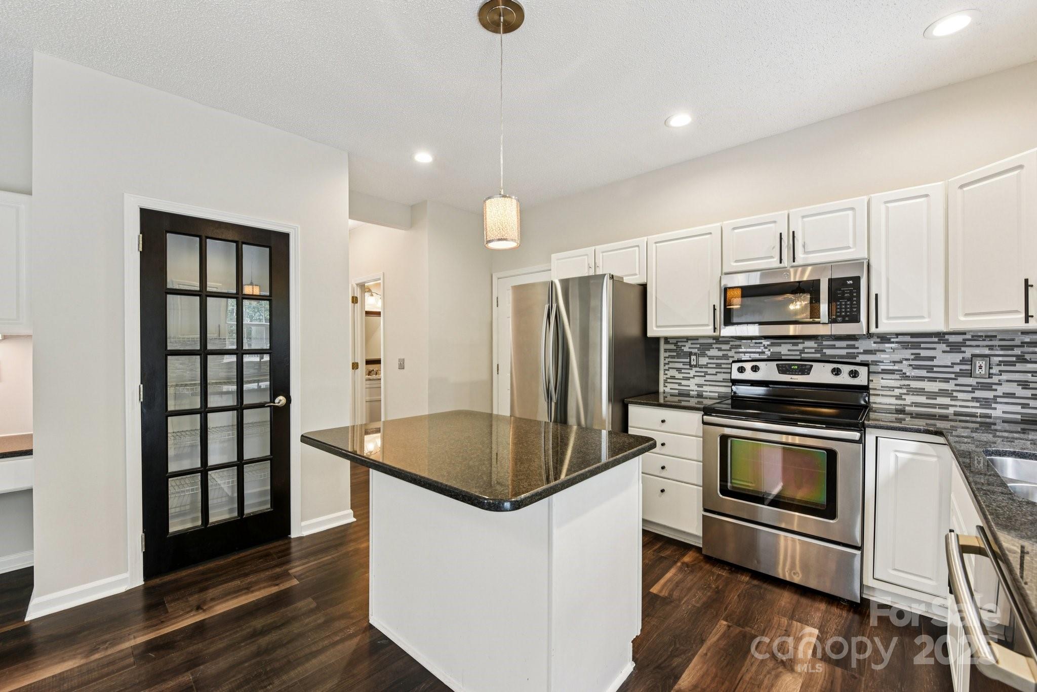 8700 Barrister Way Charlotte, NC 28216 - Photo 7 of 25 a kitchen with stainless steel appliances granite countertop a stove a refrigerator and a microwave