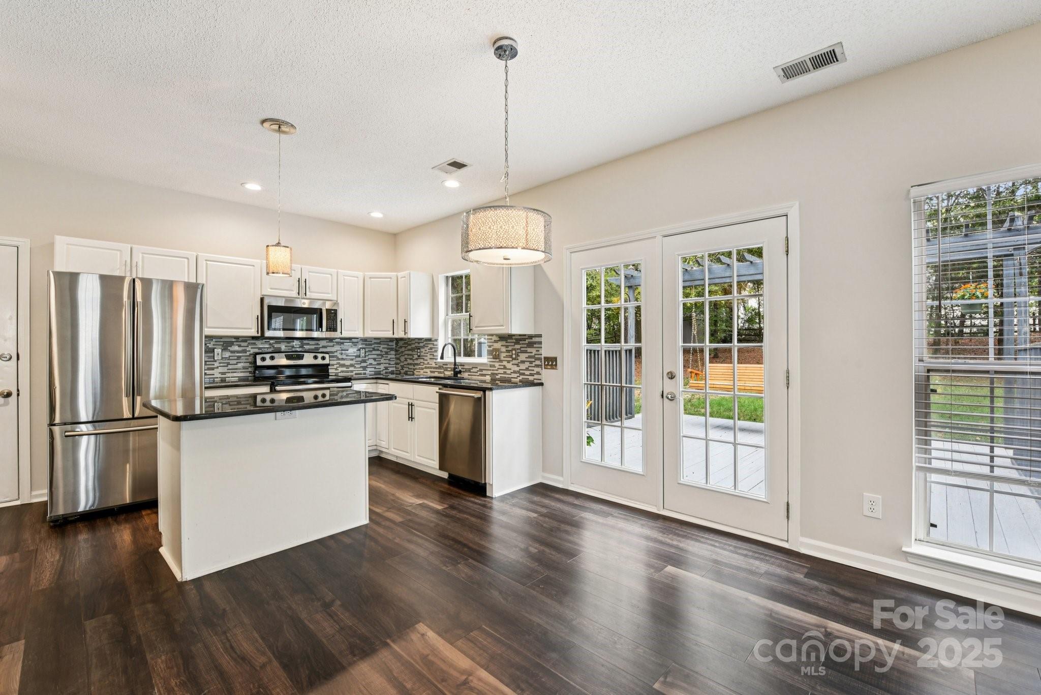 8700 Barrister Way Charlotte, NC 28216 - Photo 9 of 25 a kitchen with stainless steel appliances granite countertop a refrigerator a sink dishwasher a stove and white countertops with wooden floor