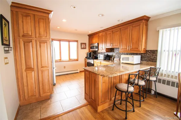 a dining room with stainless steel appliances furniture a window and a kitchen view