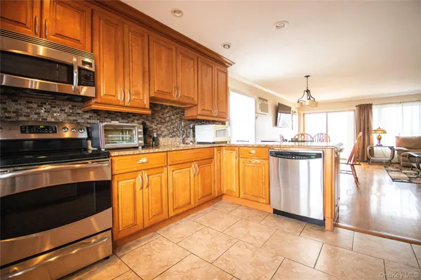a kitchen with stainless steel appliances granite countertop a stove a sink and a microwave