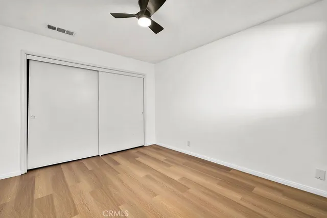 a view of a hallway with wooden floor and a potted plant