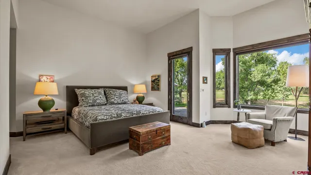 a bedroom with a bed and large windows