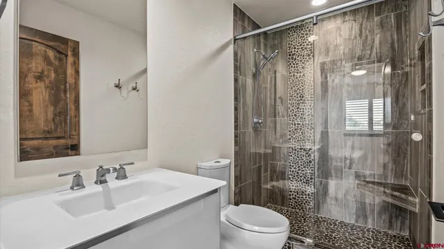 a bathroom with a sink a toilet and shower