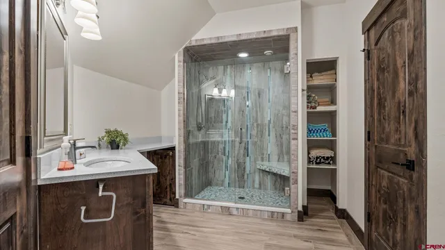 a bathroom with a sink a mirror and shower
