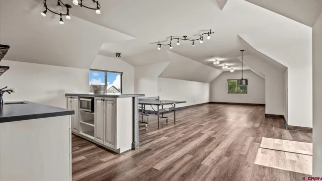 a kitchen with stainless steel appliances kitchen island hardwood floor sink and stove