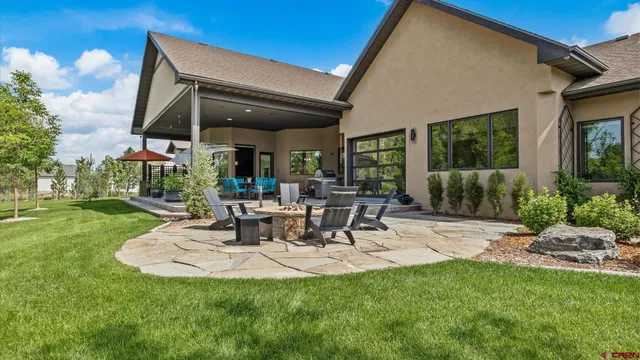 a view of a patio with table and chairs with plants and garden