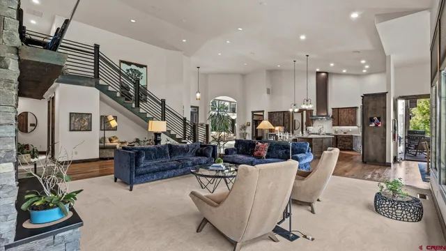 a living room with furniture potted plant and kitchen view