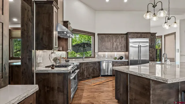 a kitchen with stainless steel appliances granite countertop a sink counter space cabinets and a stove