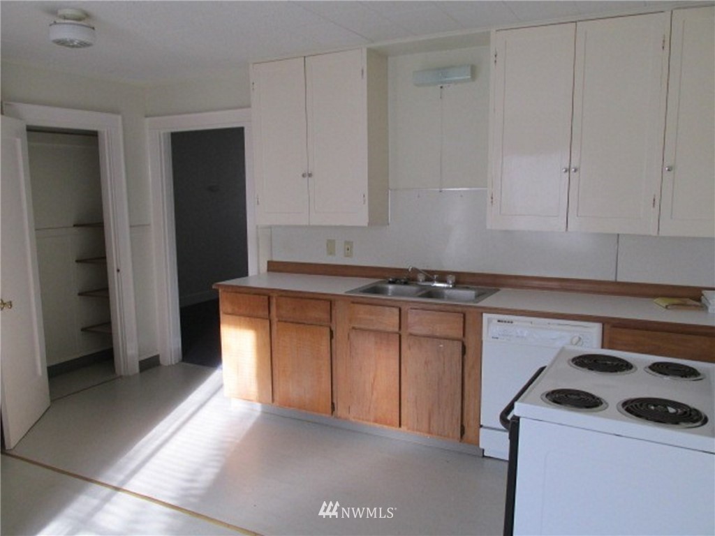 1020 J Street Hoquiam, WA 98550 - Photo 11 of 24 a kitchen with granite countertop a sink stove and cabinets