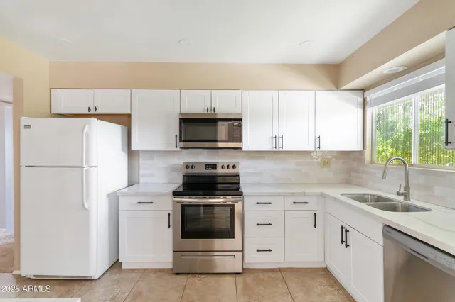 a kitchen with a refrigerator and a sink