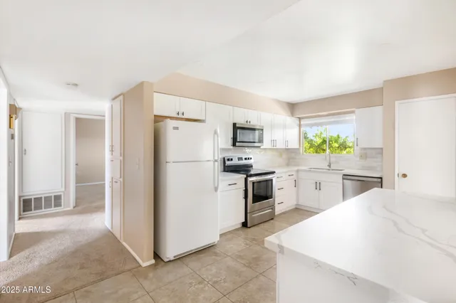 a spacious bathroom with a granite countertop sink a mirror and a