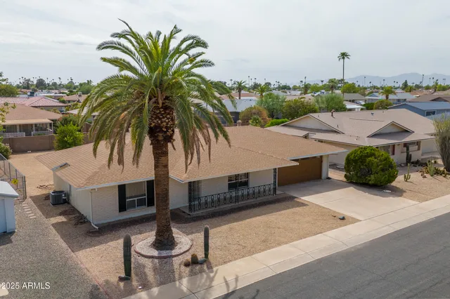 a front view of a house with a garden and a garage