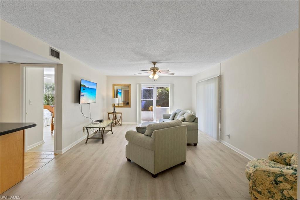 248 Palm Drive, Unit 5 Naples, FL 34112 - Photo 4 of 37 a living room with furniture and wooden floor