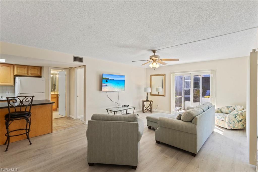 248 Palm Drive, Unit 5 Naples, FL 34112 - Photo 9 of 37 a living room with furniture and a chandelier