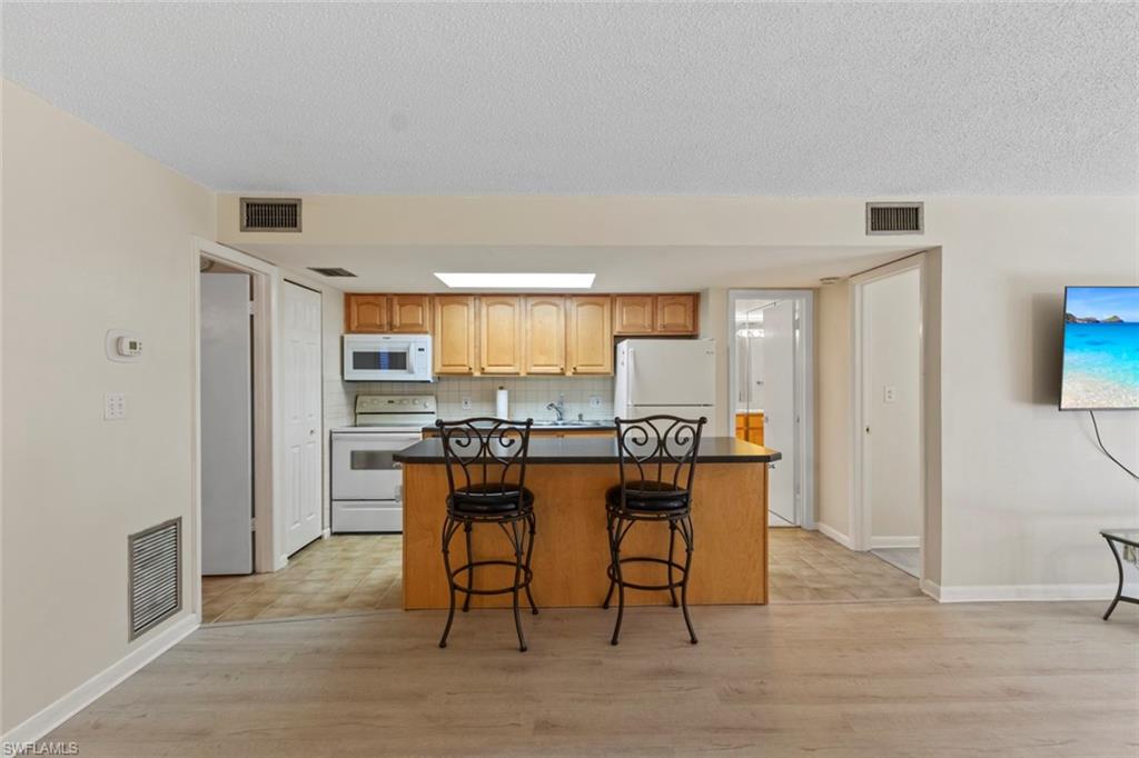 248 Palm Drive, Unit 5 Naples, FL 34112 - Photo 10 of 37 a dining room with furniture and wooden floor