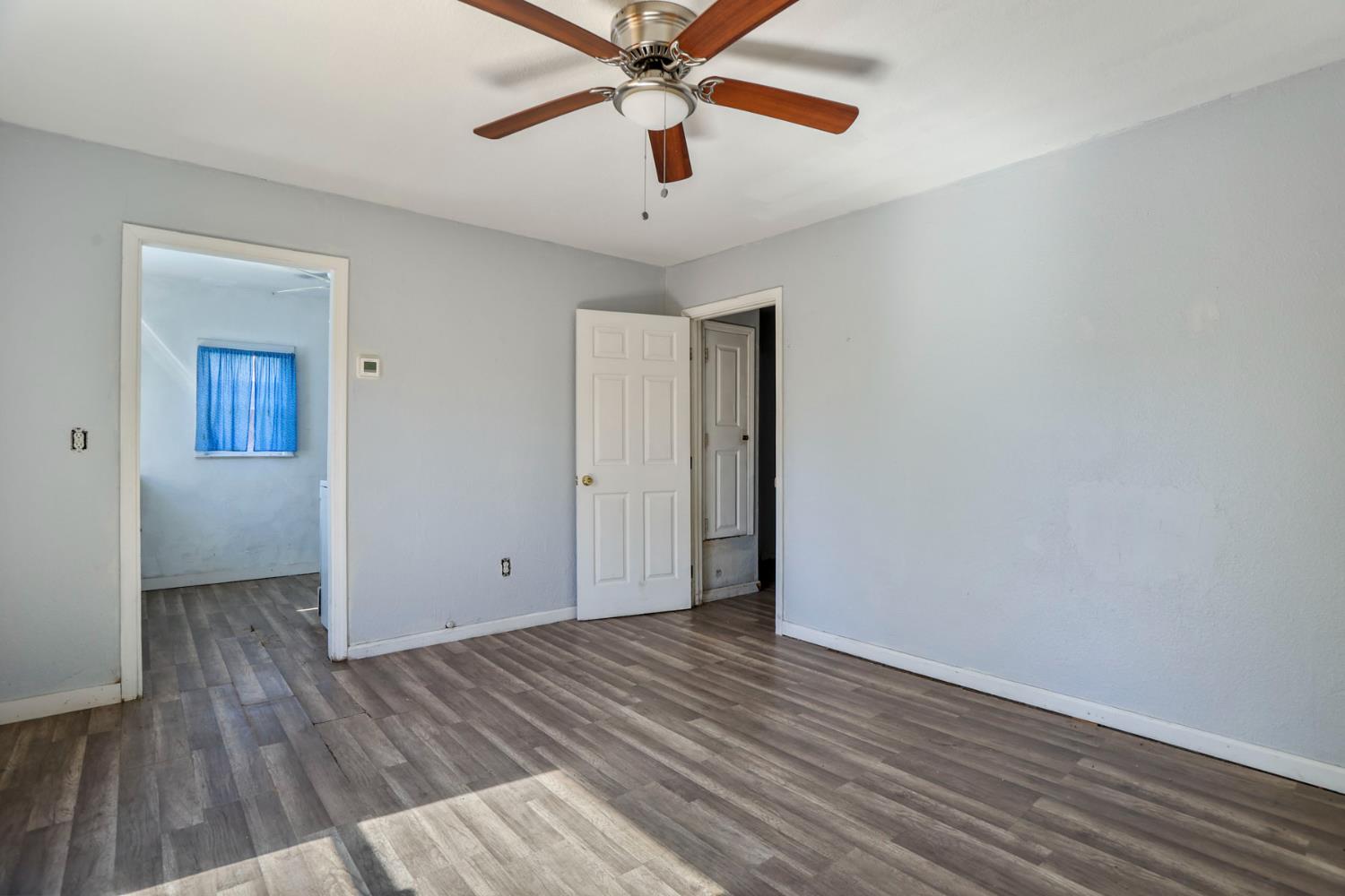 916 Elm Avenue Modesto, CA 95351 - Photo 39 of 52 Bedroom area in rear dwelling with wood-look flooring, neutral walls, closet access, and functional layout.
