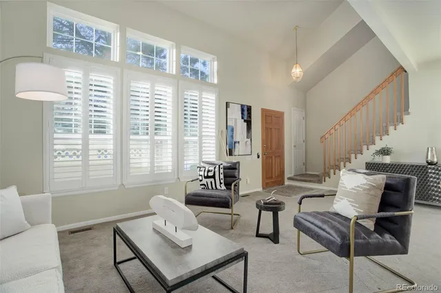 a living room with furniture and large windows